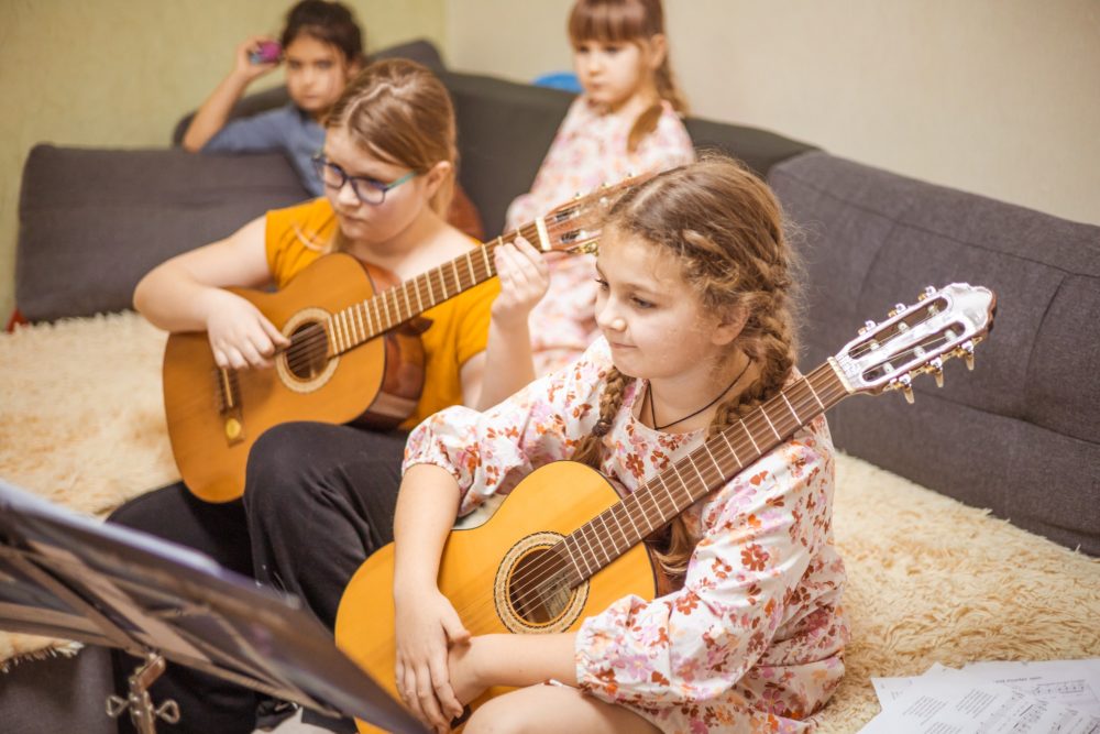 teenage girls rehearsing guitar at home, musical talented children, music lesson with teacher